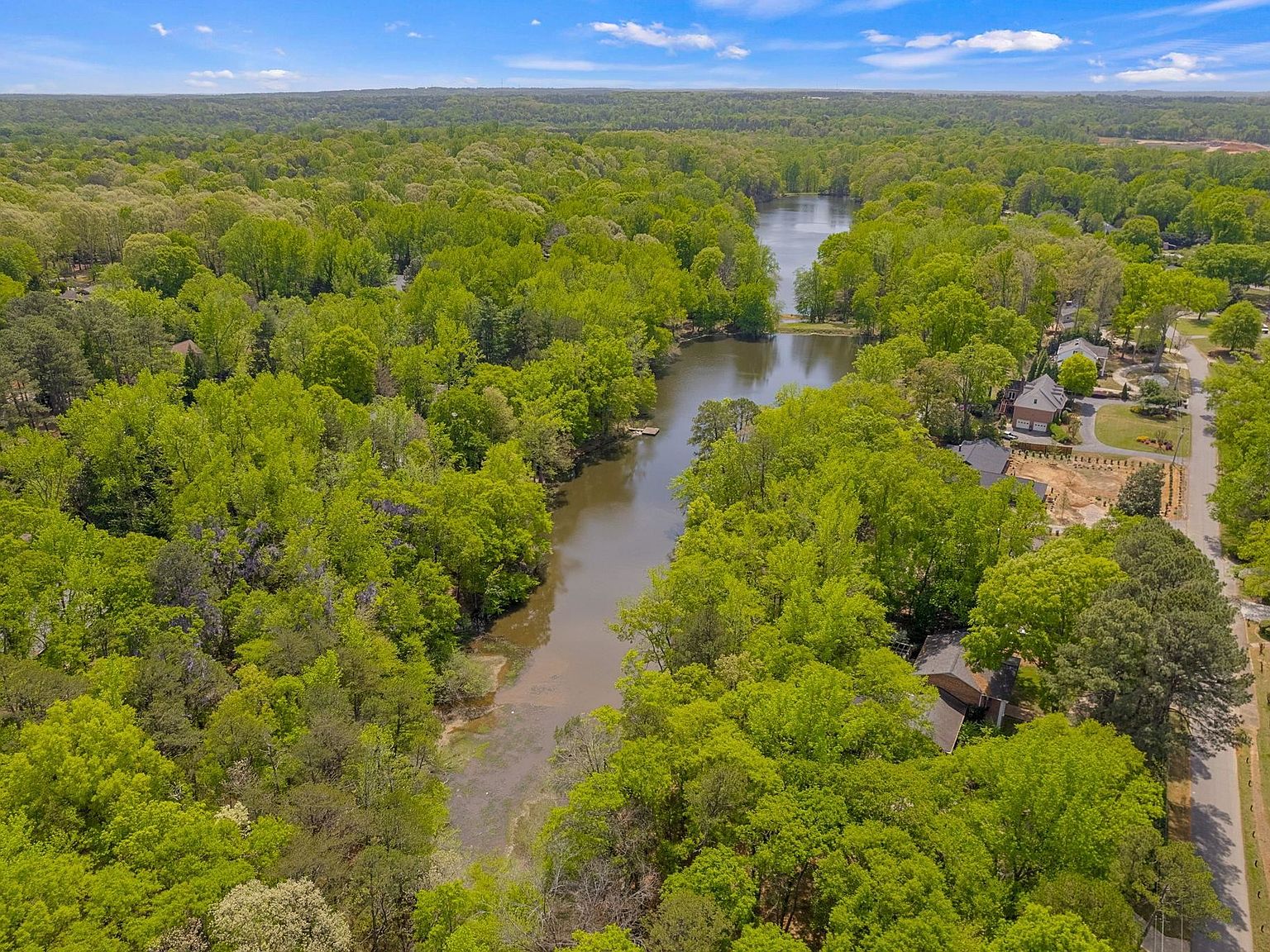 Aerial view of the wooded 2.19-acre lot with Lake Calhoun winding through the trees behind the property
