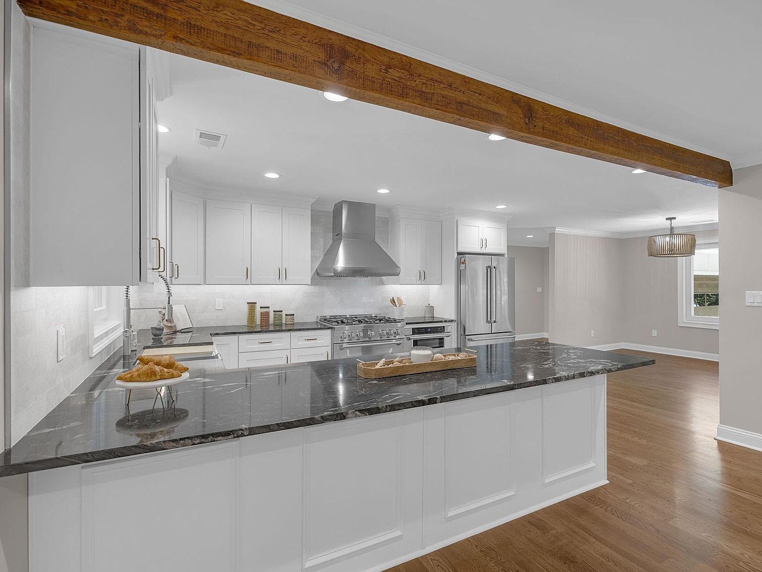 Kitchen island detail showing the exposed wood beam ceiling and oak hardwood floors